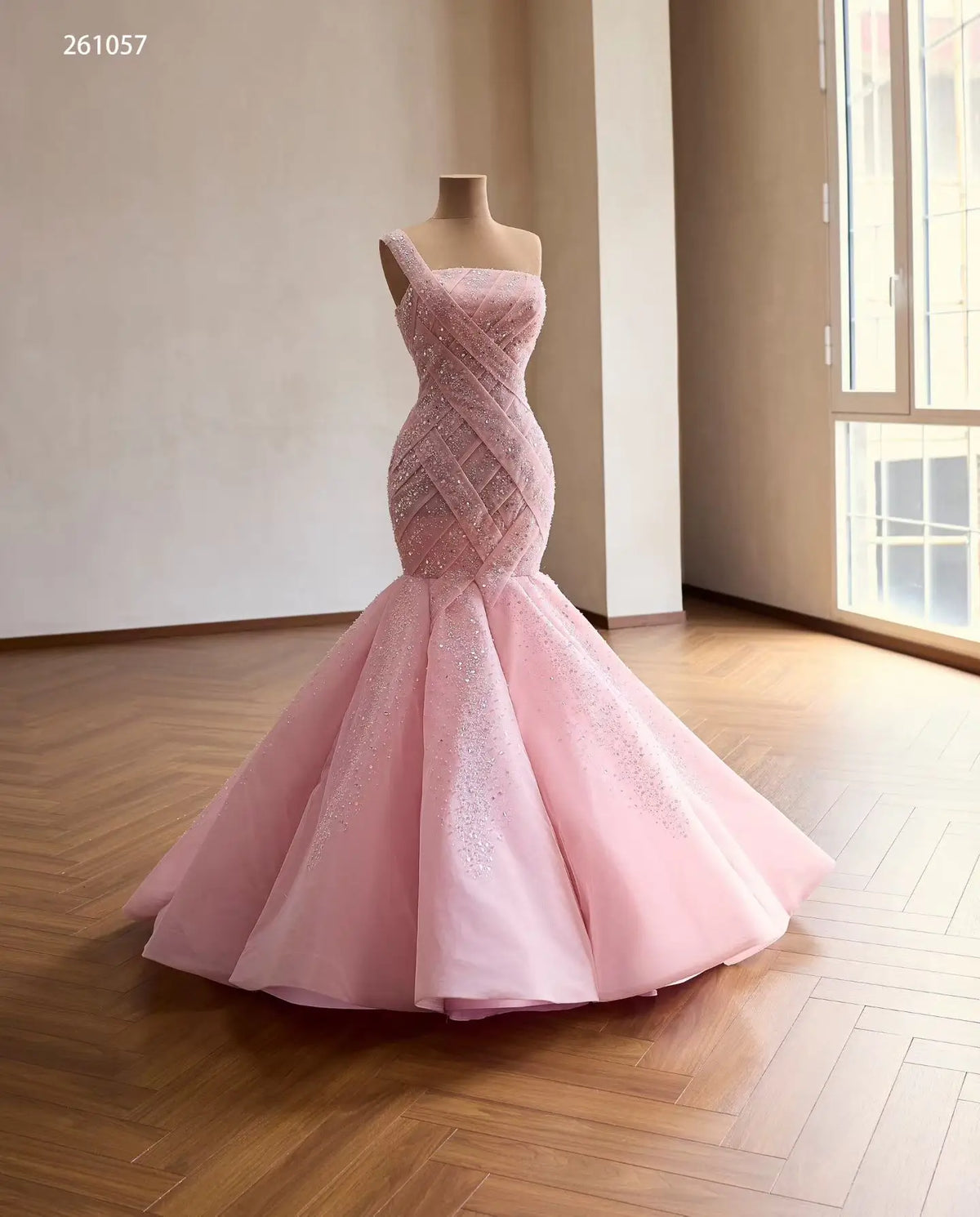 Pink one-shoulder mermaid quinceañera dress with a sparkling crisscross lattice bodice and full flared skirt.