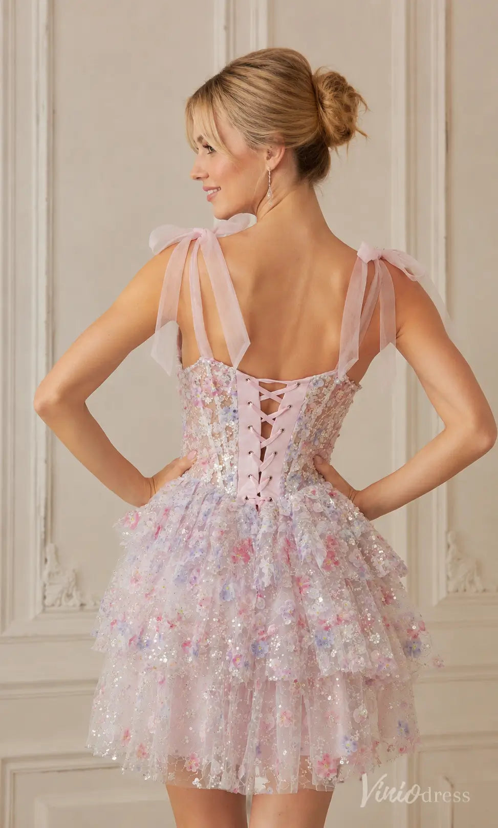 S26121 light pink sequin mini dress with tiered ruffle skirt, lace-up corset back, and sheer shoulder ties.
