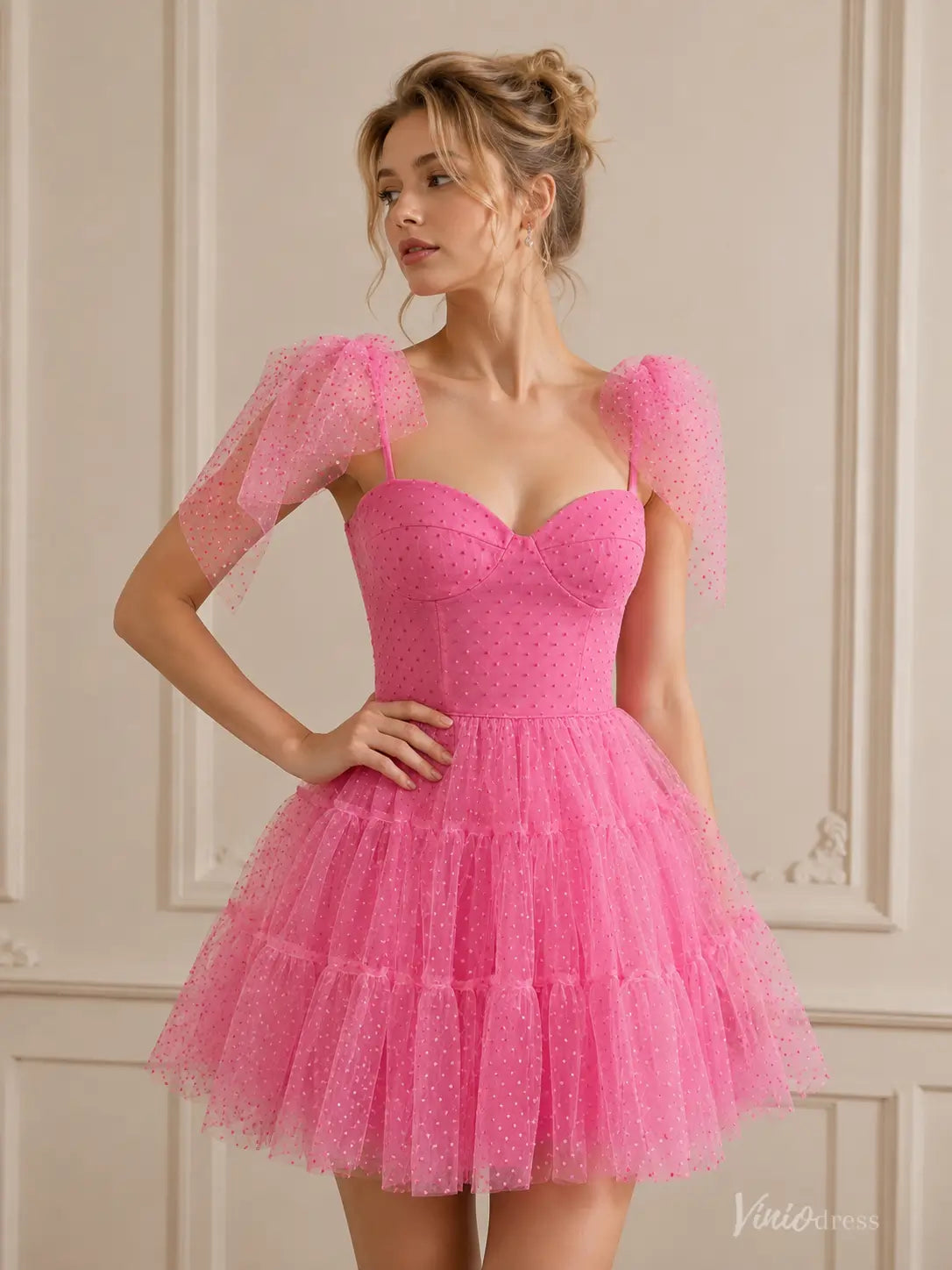 Pink strapless homecoming dress with spaghetti straps, ruffled tulle skirt, and delicate polka dot detailing.