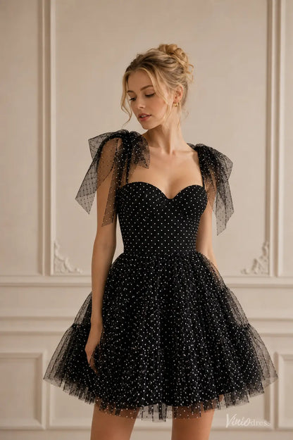 Black strapless homecoming dress with white polka dots, spaghetti straps, and a voluminous ruffled tulle skirt.