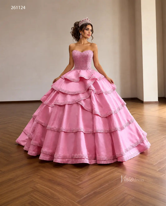 Pink strapless quinceañera dress with a pearl-beaded corset and a dramatic tiered ruffle skirt with beaded edges.