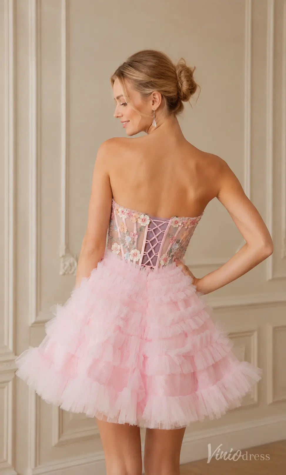 Pink strapless mini dress with ruffled tulle skirt and floral embroidered corset bodice with lace-up back.