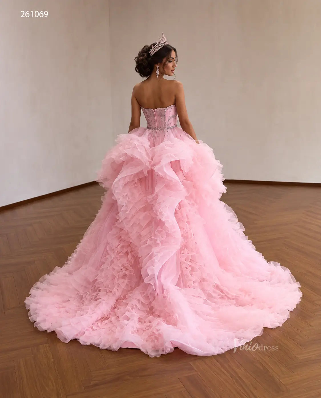 Pink tulle quinceañera ball gown with a crystal-beaded corset bodice and cascading waterfall ruffle skirt.