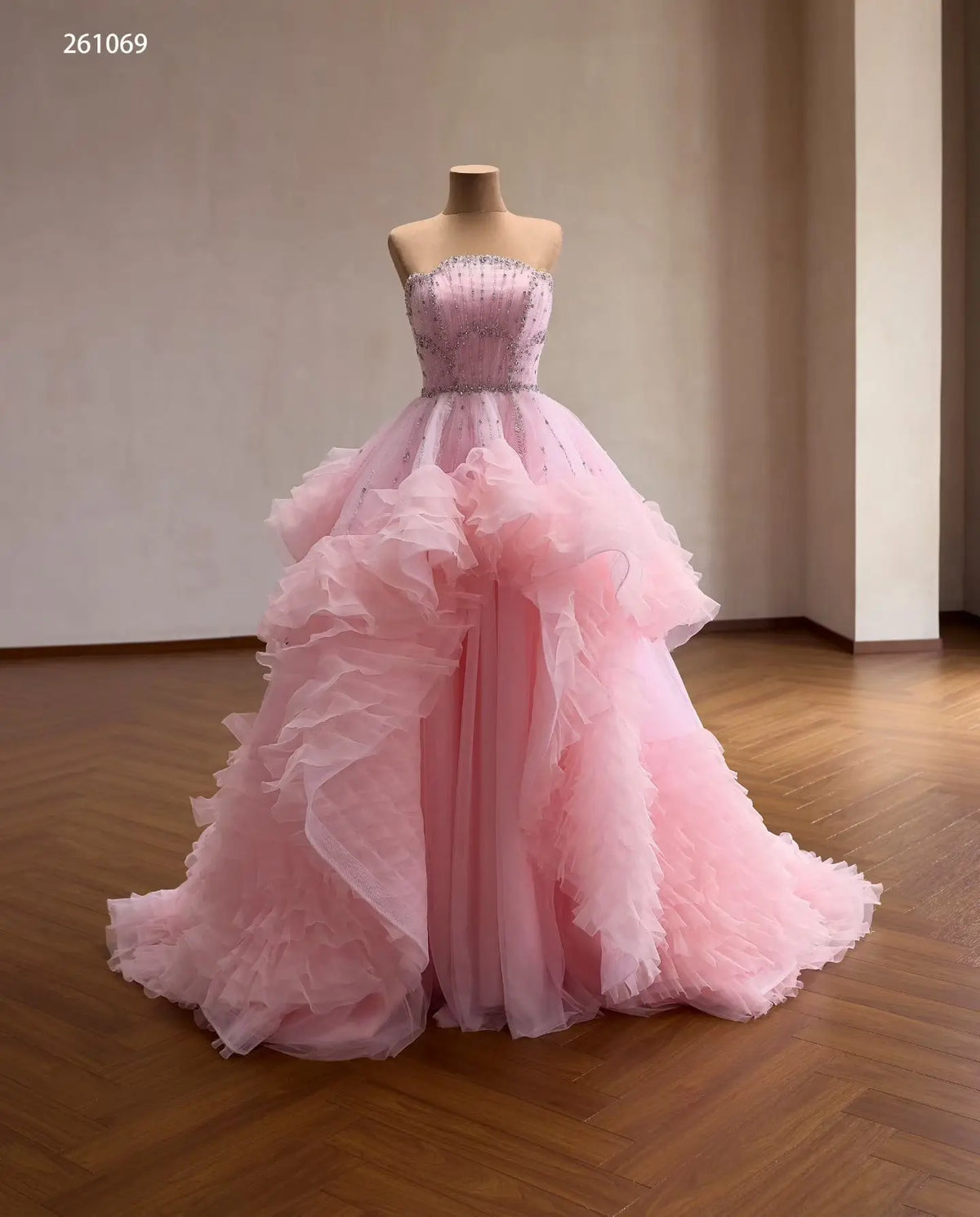 Pink tulle quinceañera ball gown with a crystal-beaded fan corset and cascading waterfall ruffle skirt.