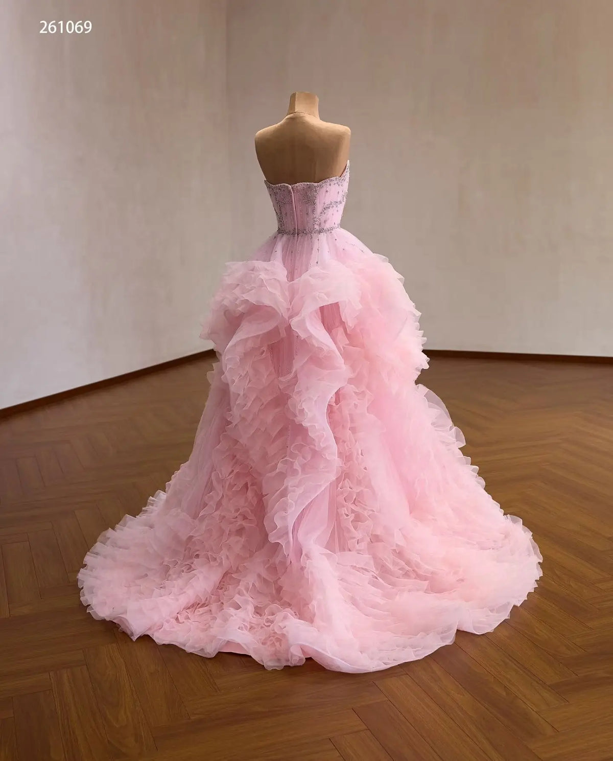 Pink tulle quinceañera ball gown with a crystal-beaded corset bodice and cascading waterfall ruffle skirt.