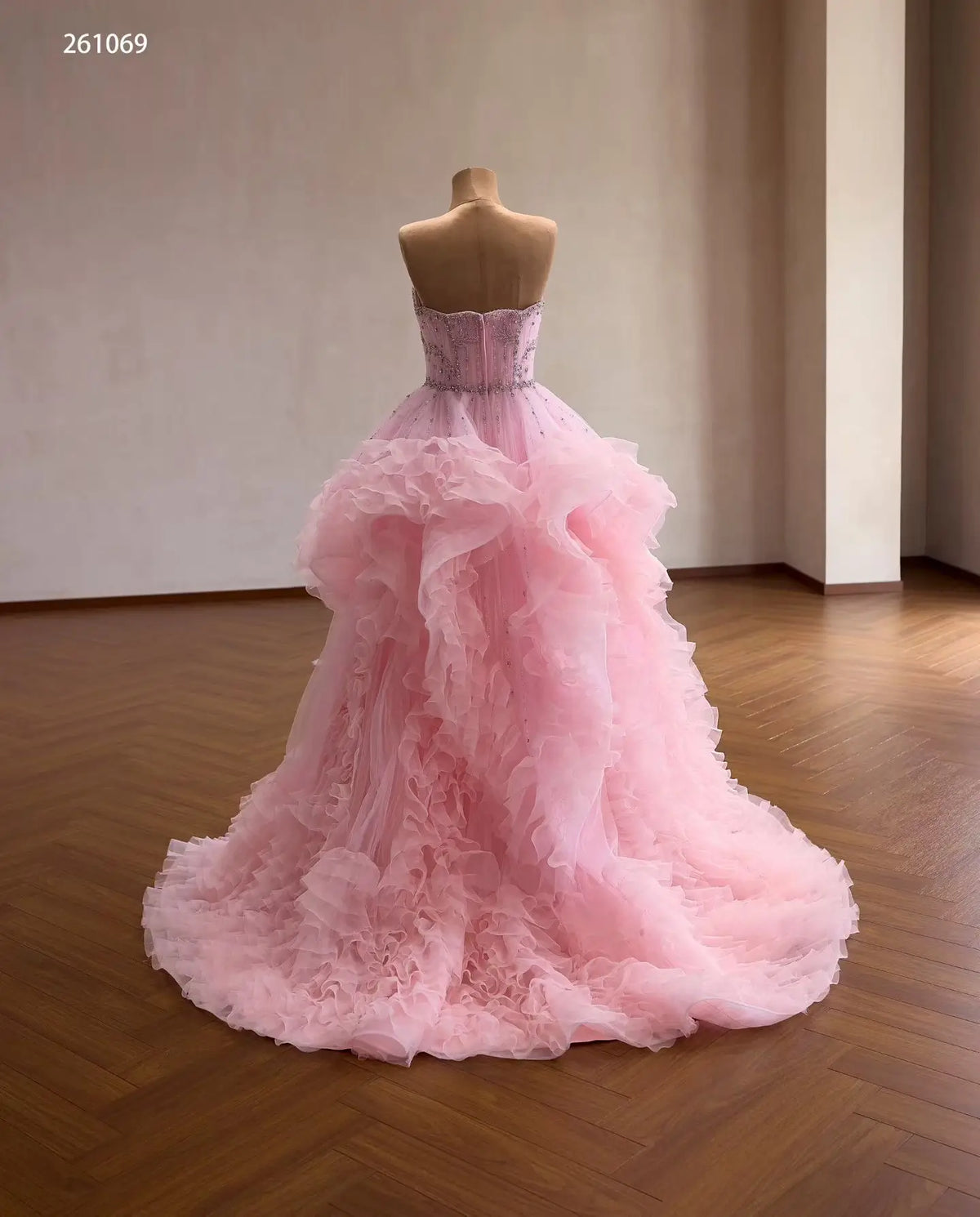 Pink tulle quinceañera ball gown with a crystal-beaded corset bodice and cascading waterfall ruffle skirt.