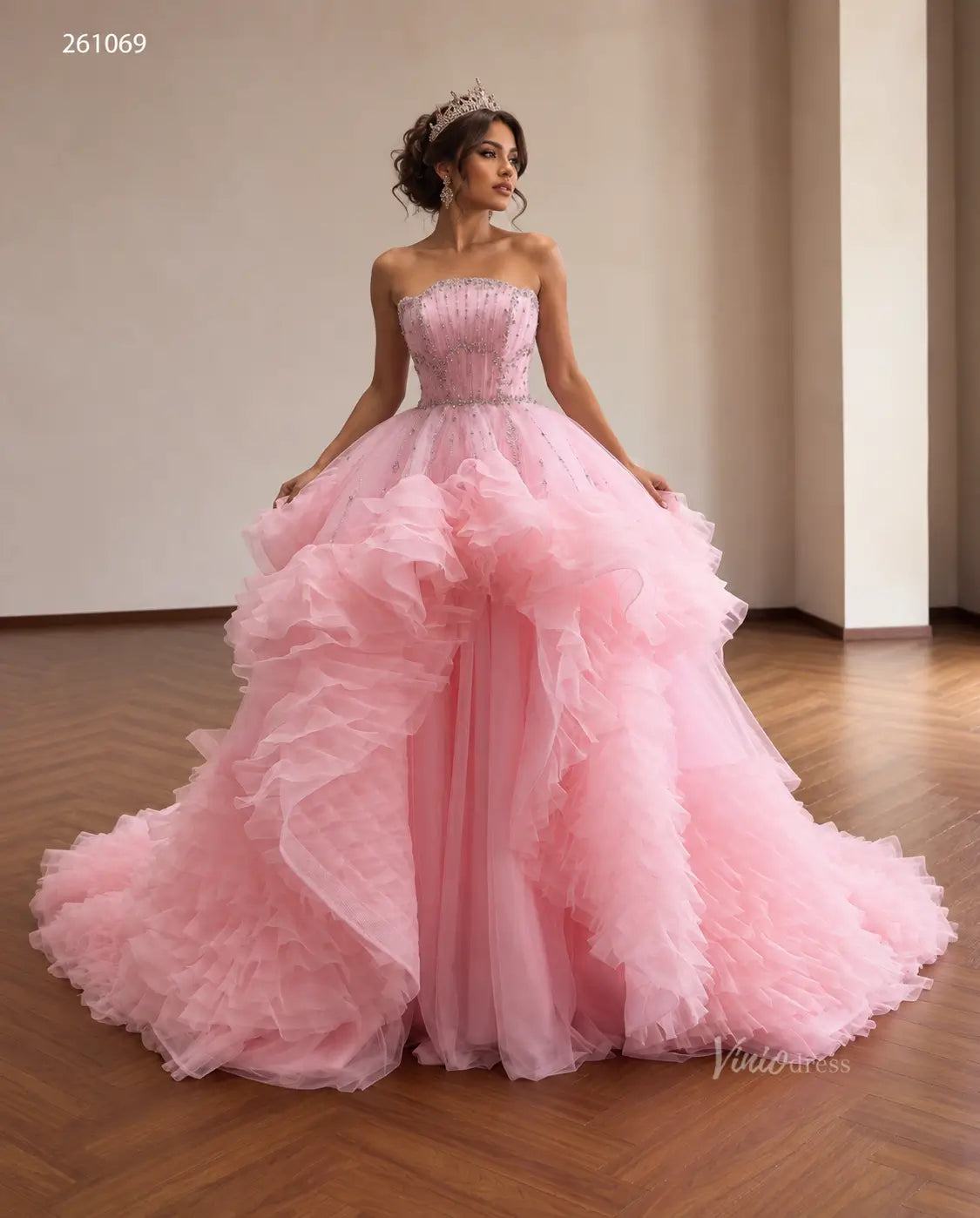 Pink tulle quinceañera ball gown with a crystal-beaded fan corset bodice and cascading waterfall ruffle skirt.