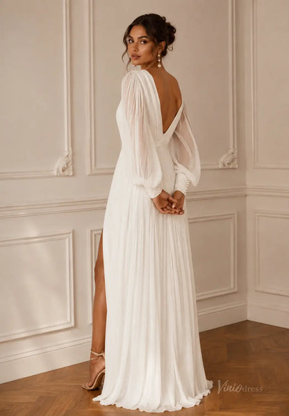 White pleated wedding dress with sheer long sleeves, a deep V-back, and a high leg slit in a classic interior setting.