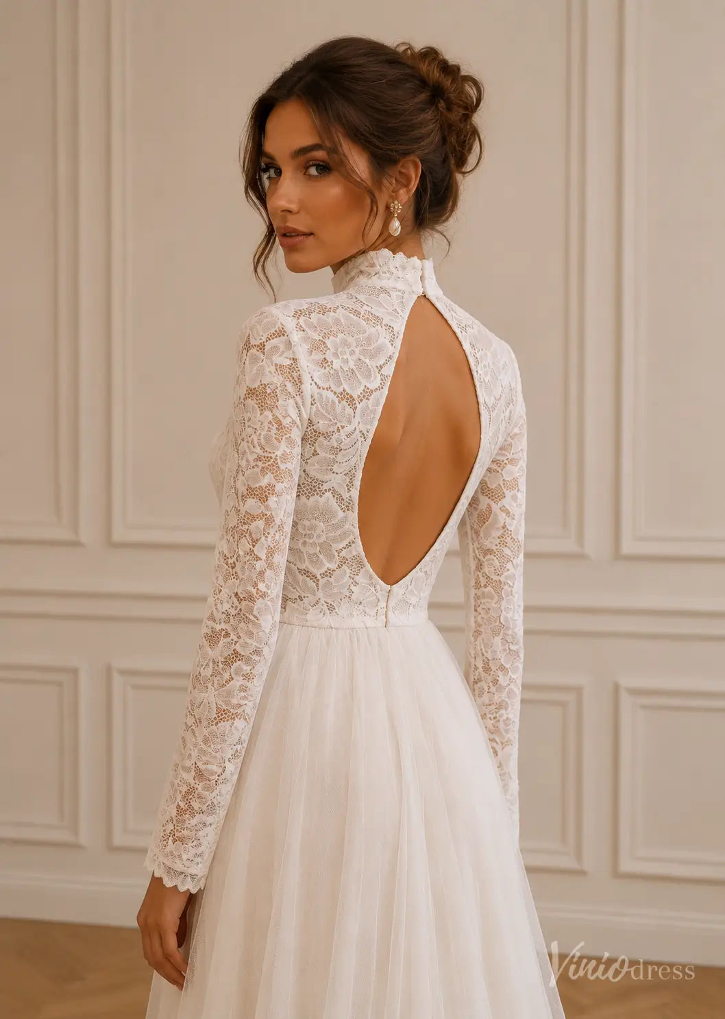 White lace wedding dress with long sleeves, a high neck, and an elegant open back design.