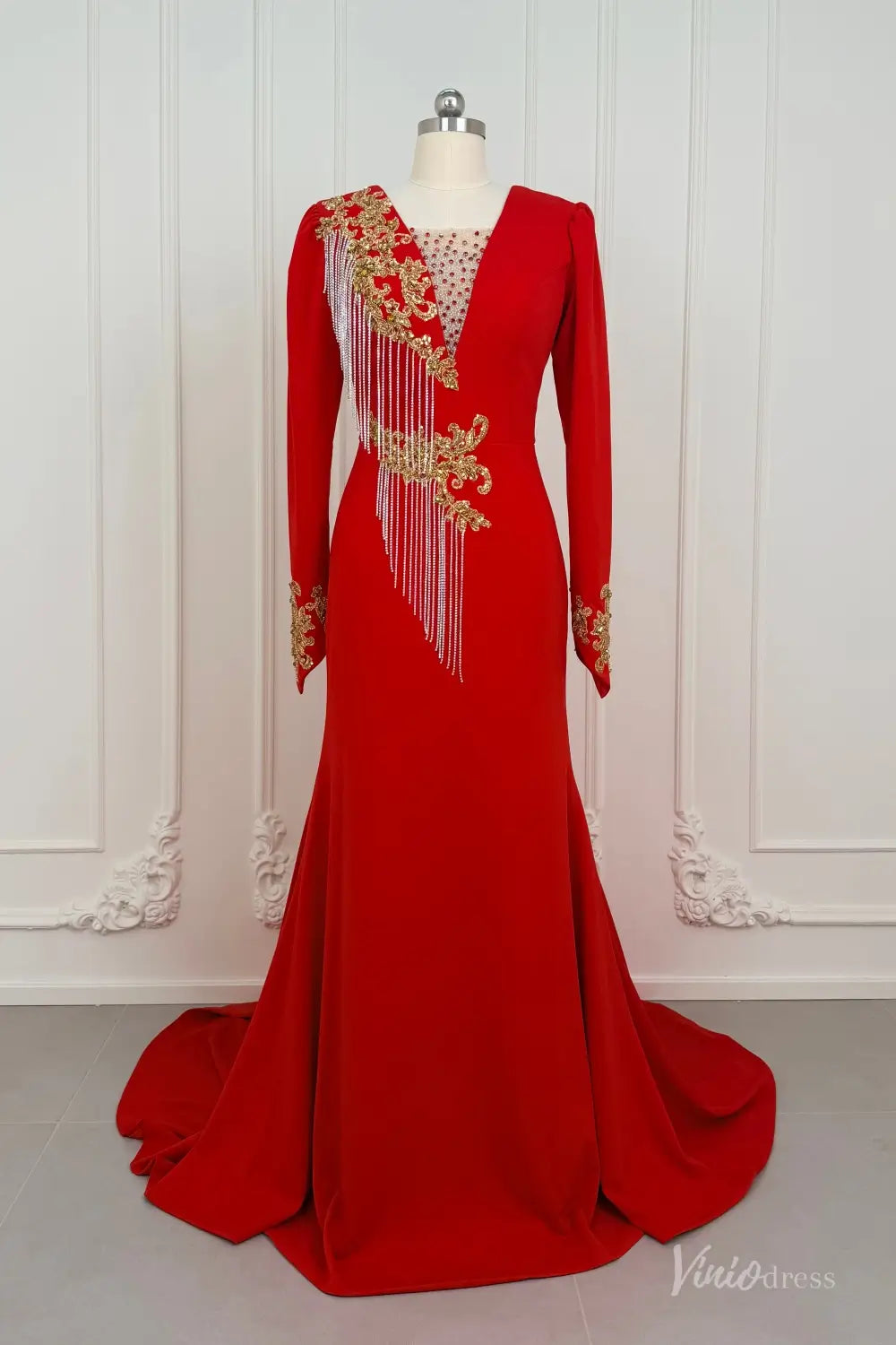 Red long sleeve evening dress with gold beaded lace, V-neck, and fringe on a mannequin.