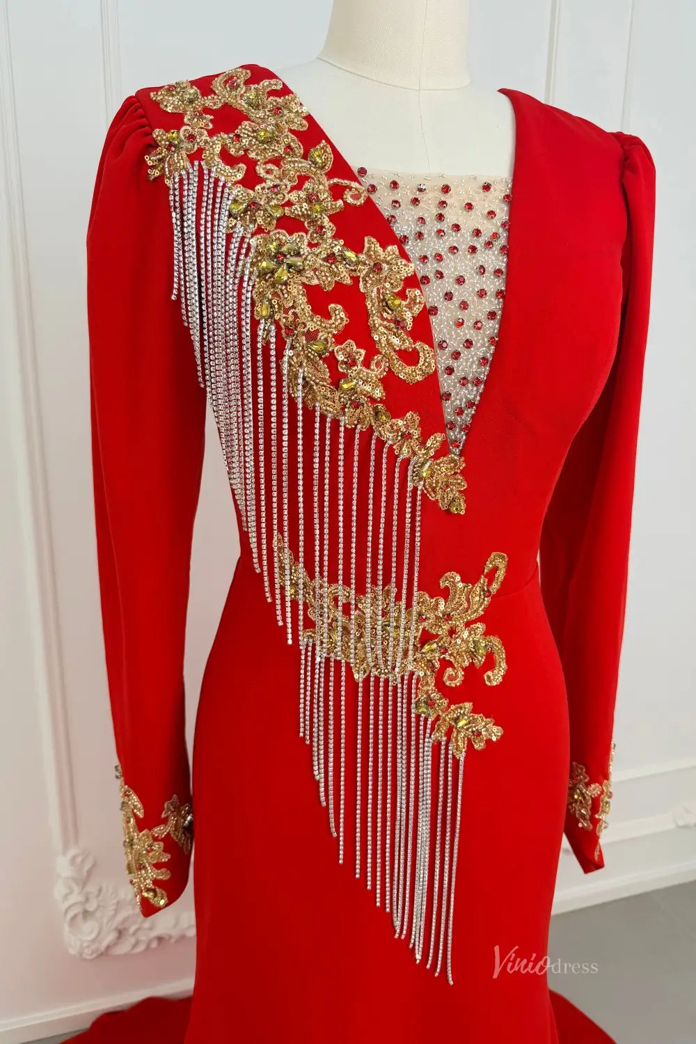 Red long sleeve evening dress with gold beaded lace and silver fringe detailing.