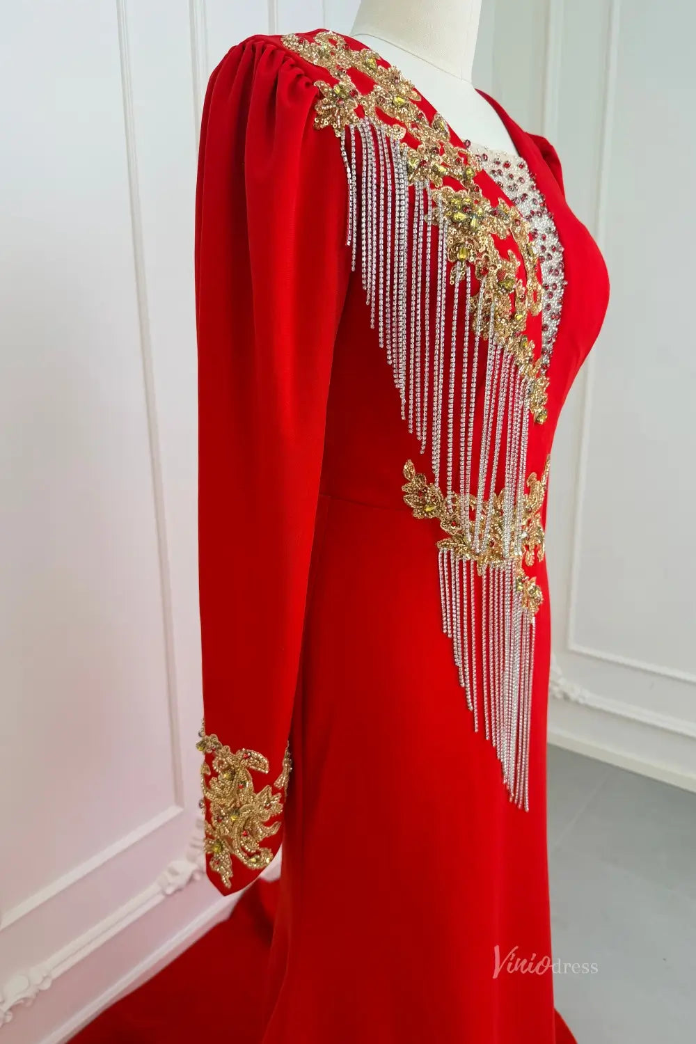 Red long sleeve evening dress with gold beaded lace and silver fringe detailing.
