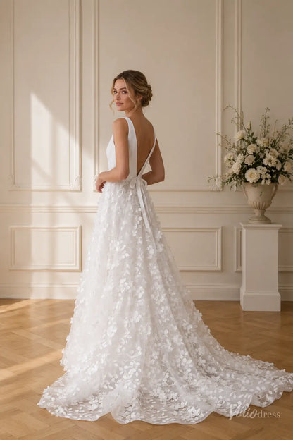 A-line wedding dress with a deep V-back, wide straps, and a tulle skirt adorned with 3D floral lace appliqués.