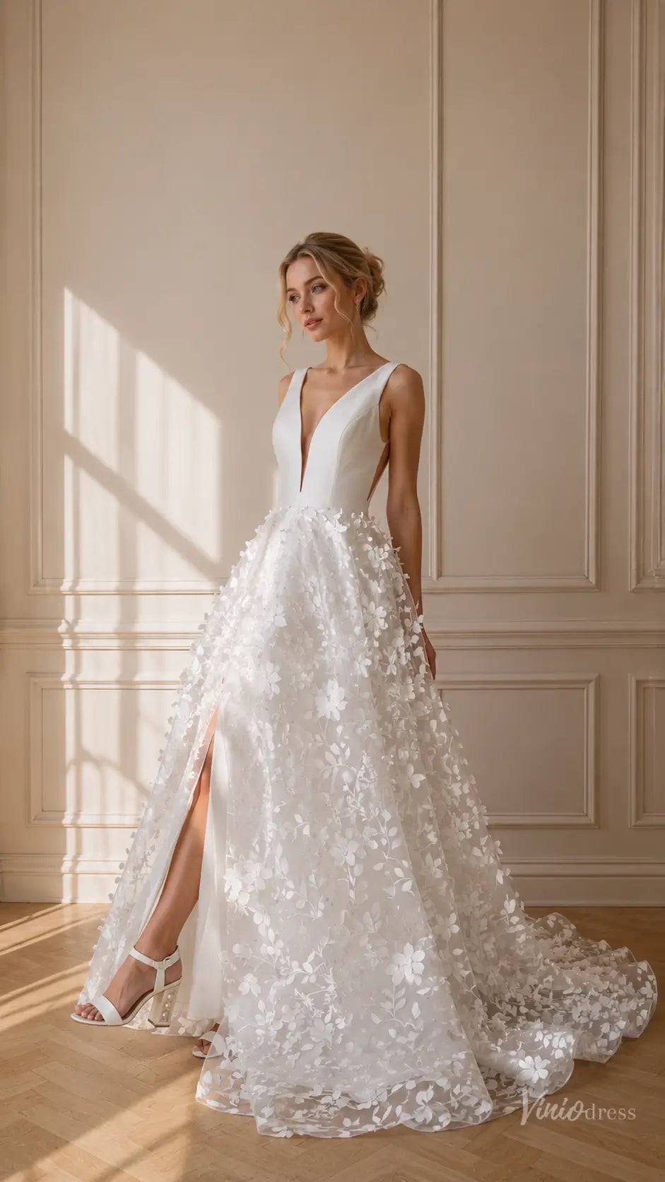 White A-line wedding dress with a deep V-neck, 3D floral tulle skirt, and high leg slit.