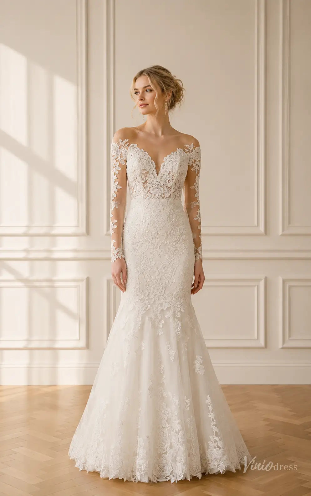 Ivory mermaid wedding dress with long illusion lace sleeves, floral appliqué, and a deep V-neckline.