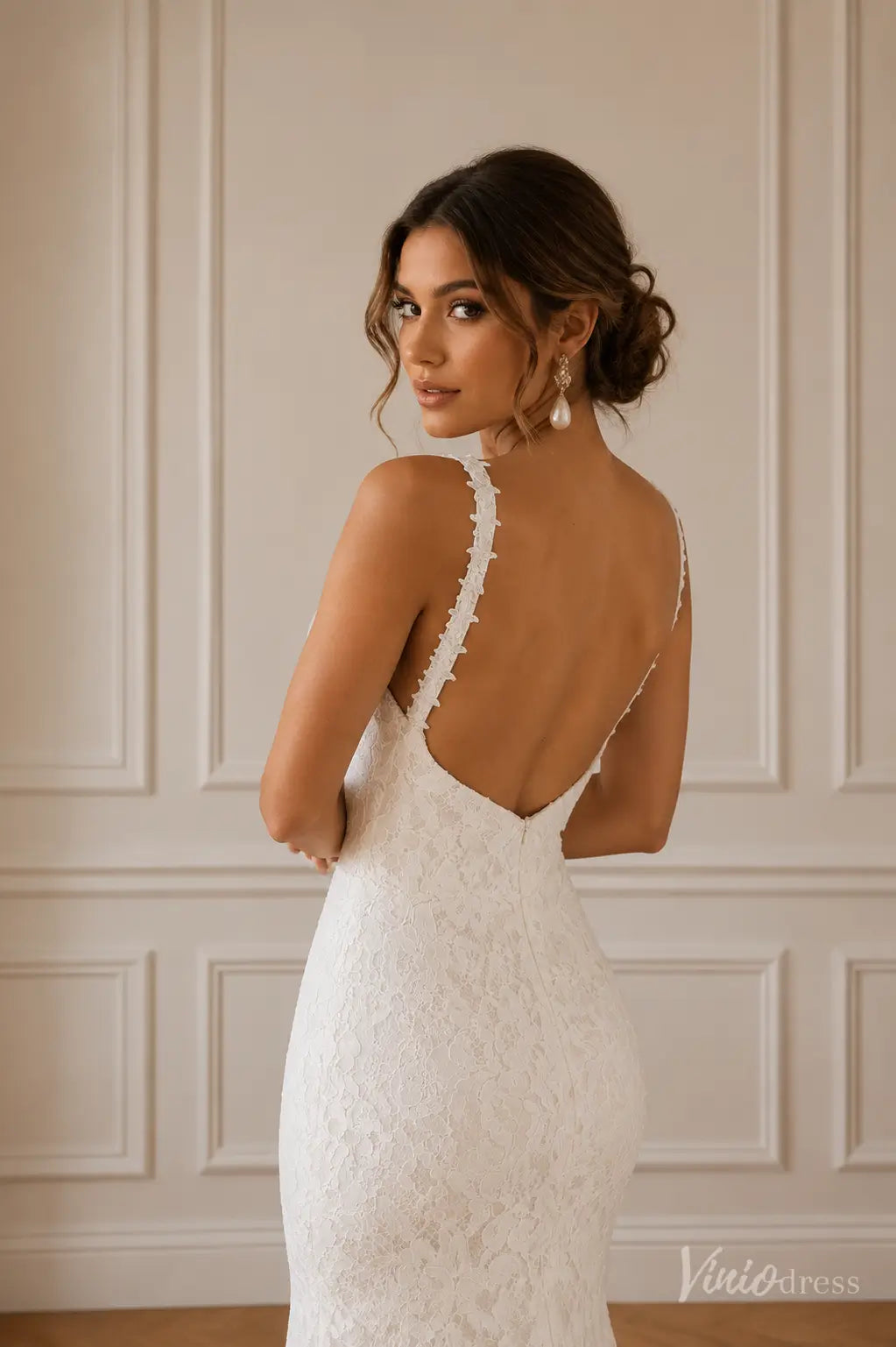 Boho mermaid wedding dress in white floral lace with a low V-back and delicate lace-trimmed straps.