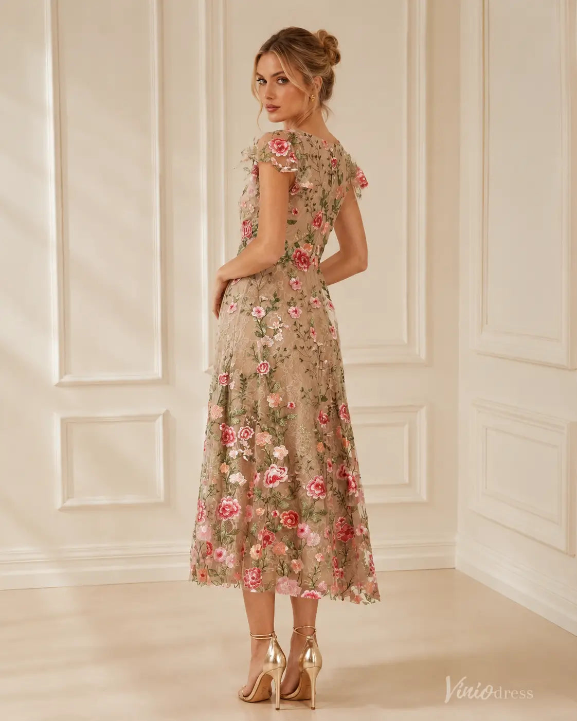 Midi length V-neck evening dress in beige with colorful floral embroidery, cap sleeves, and a flattering A-line silhouette.