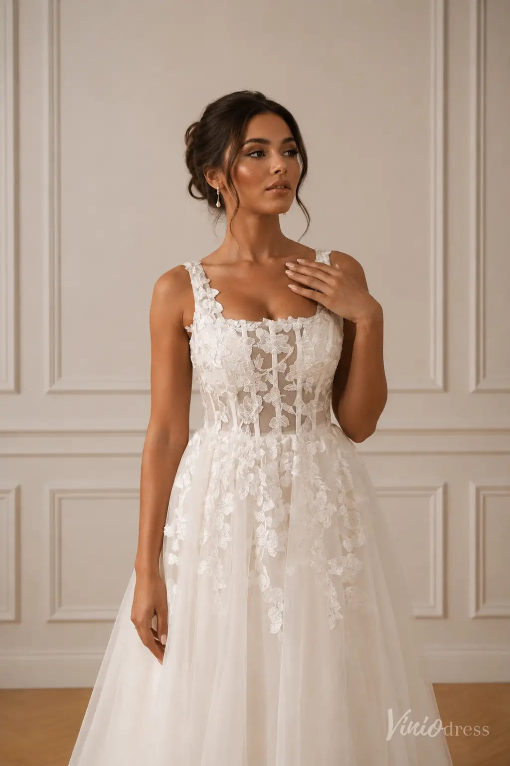 White A-line wedding dress with a square neckline, corset-style bodice, and delicate floral lace appliques.