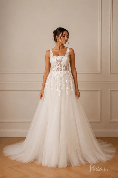 White A-line wedding dress with a square neckline, sheer corset bodice, and delicate floral lace appliqué on tulle.
