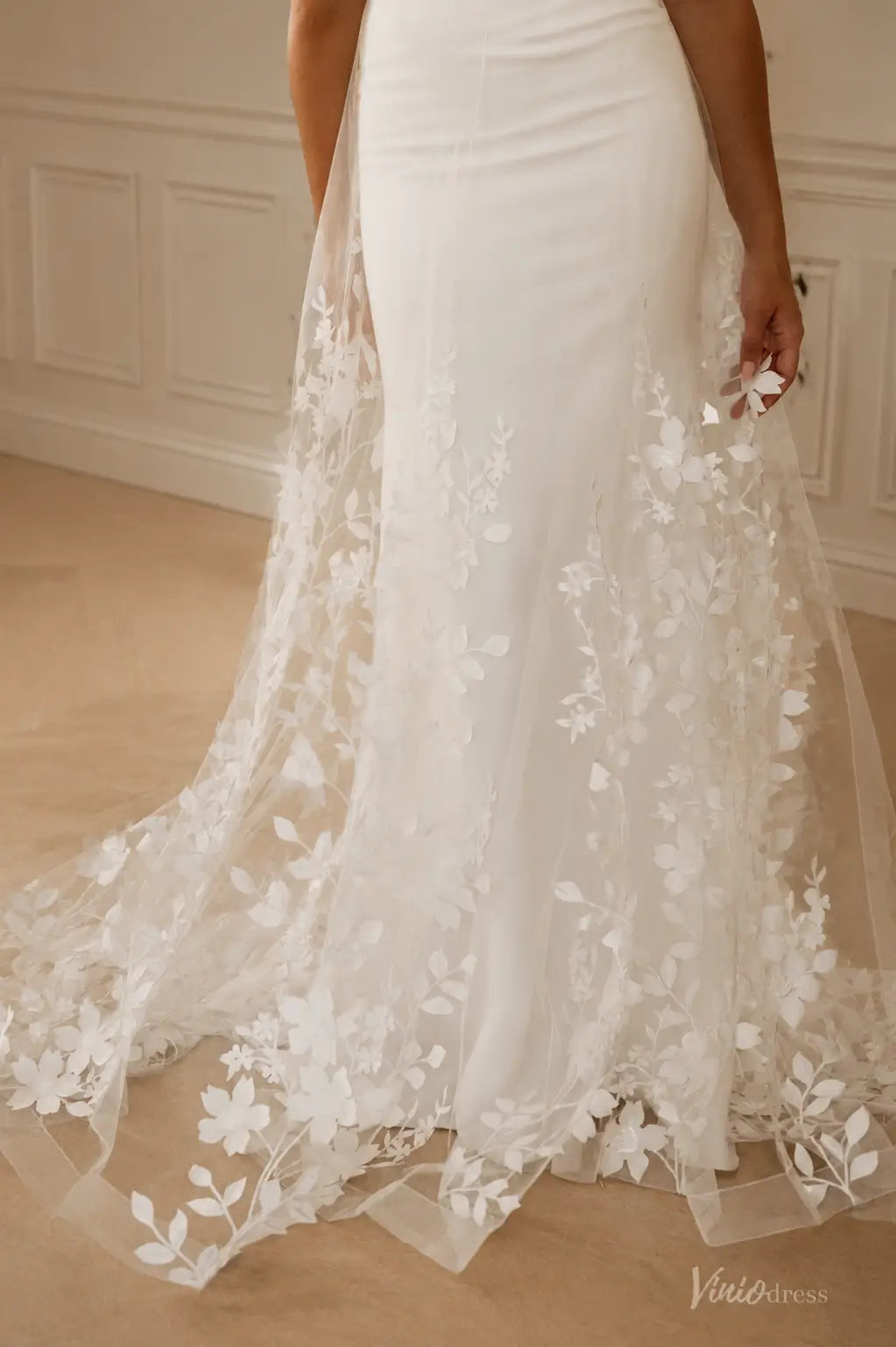 ML192 white wedding dress featuring a sleek fitted skirt with a sheer, floral-embroidered tulle overlay and train.