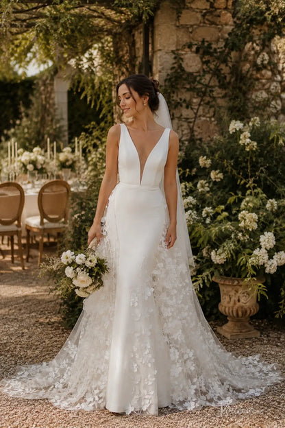 ML192 white V-neck wedding dress with a fitted bodice and floral lace overlay skirt, featuring a long train and sheer veil.