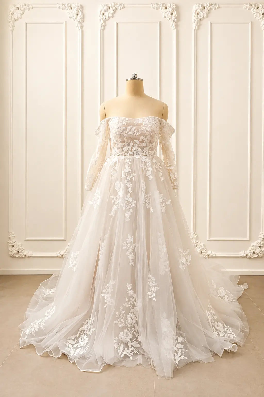 Ivory off-shoulder wedding dress with long lace sleeves, floral appliqué, and a voluminous tulle A-line skirt.