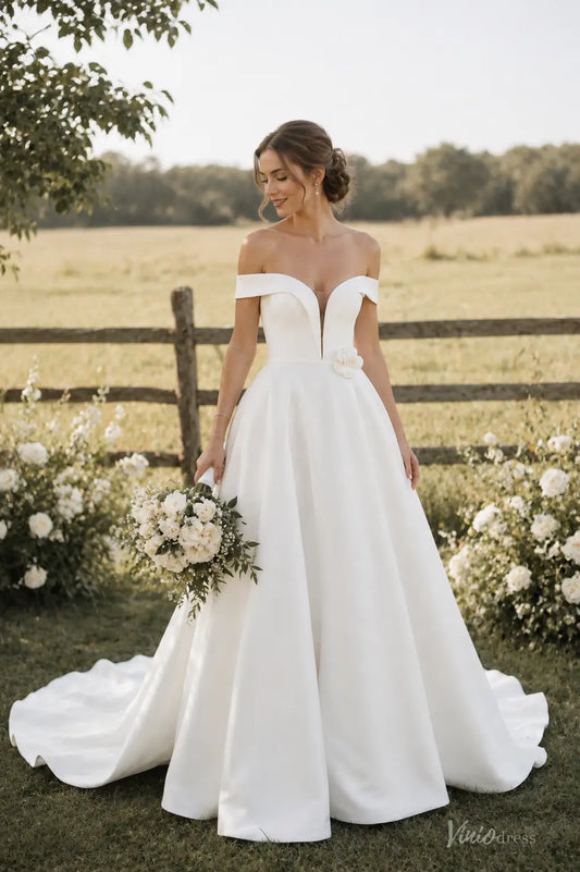 Ivory satin A-line wedding dress with off-shoulder sleeves, plunging V-neckline, and 3D floral waist detail.