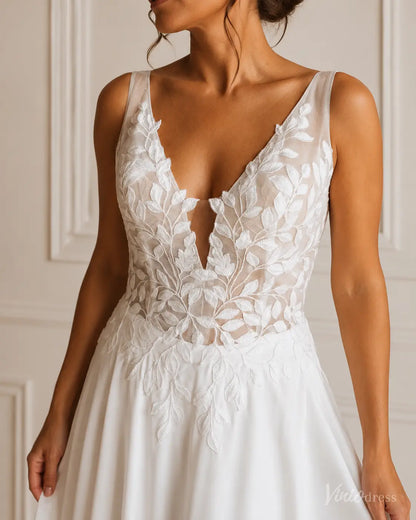 White A-line wedding dress featuring a deep V-neckline, sheer bodice, and intricate white leaf embroidery.