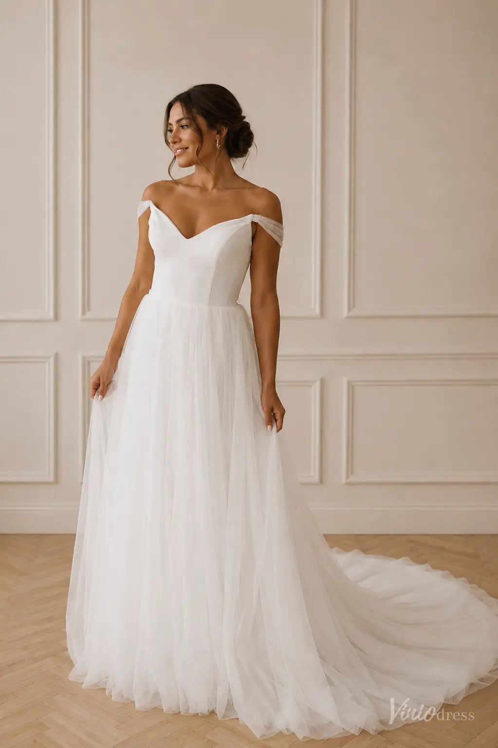 White A-line wedding dress with off-the-shoulder tulle sleeves, a sweetheart neckline, and a flowing tulle skirt.
