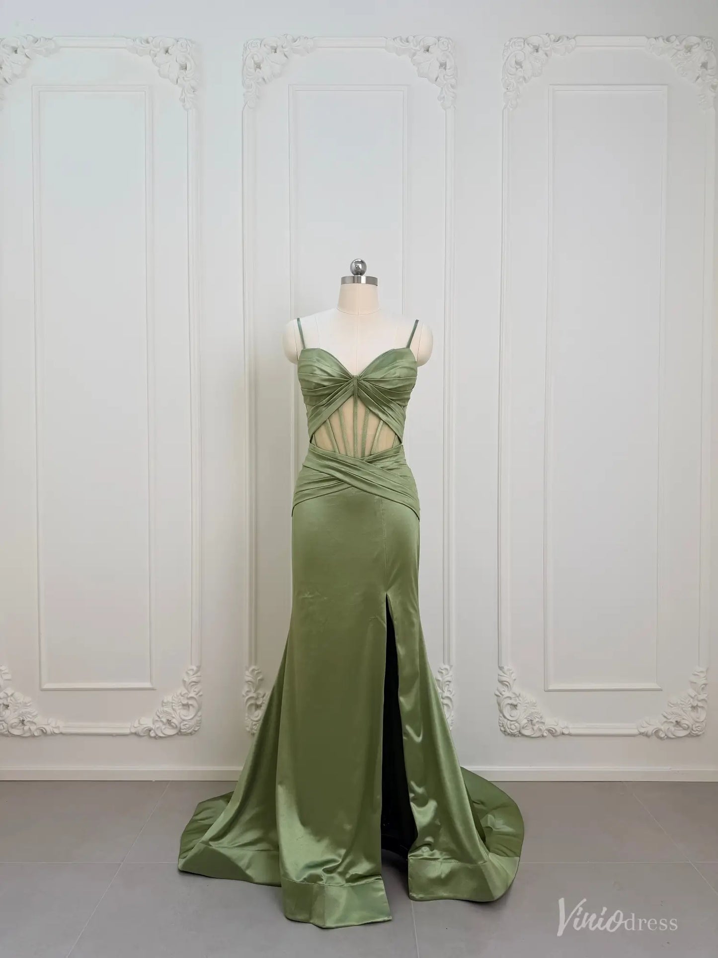 Sage green satin mermaid prom dress with a corset cutout bodice, ruched waist, and high leg slit on a mannequin.