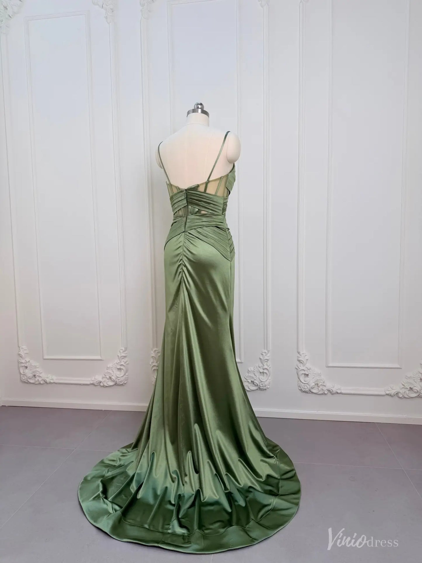 Sage green satin mermaid prom dress with a corset-style open back, ruched waist, and floor-length train on a mannequin.