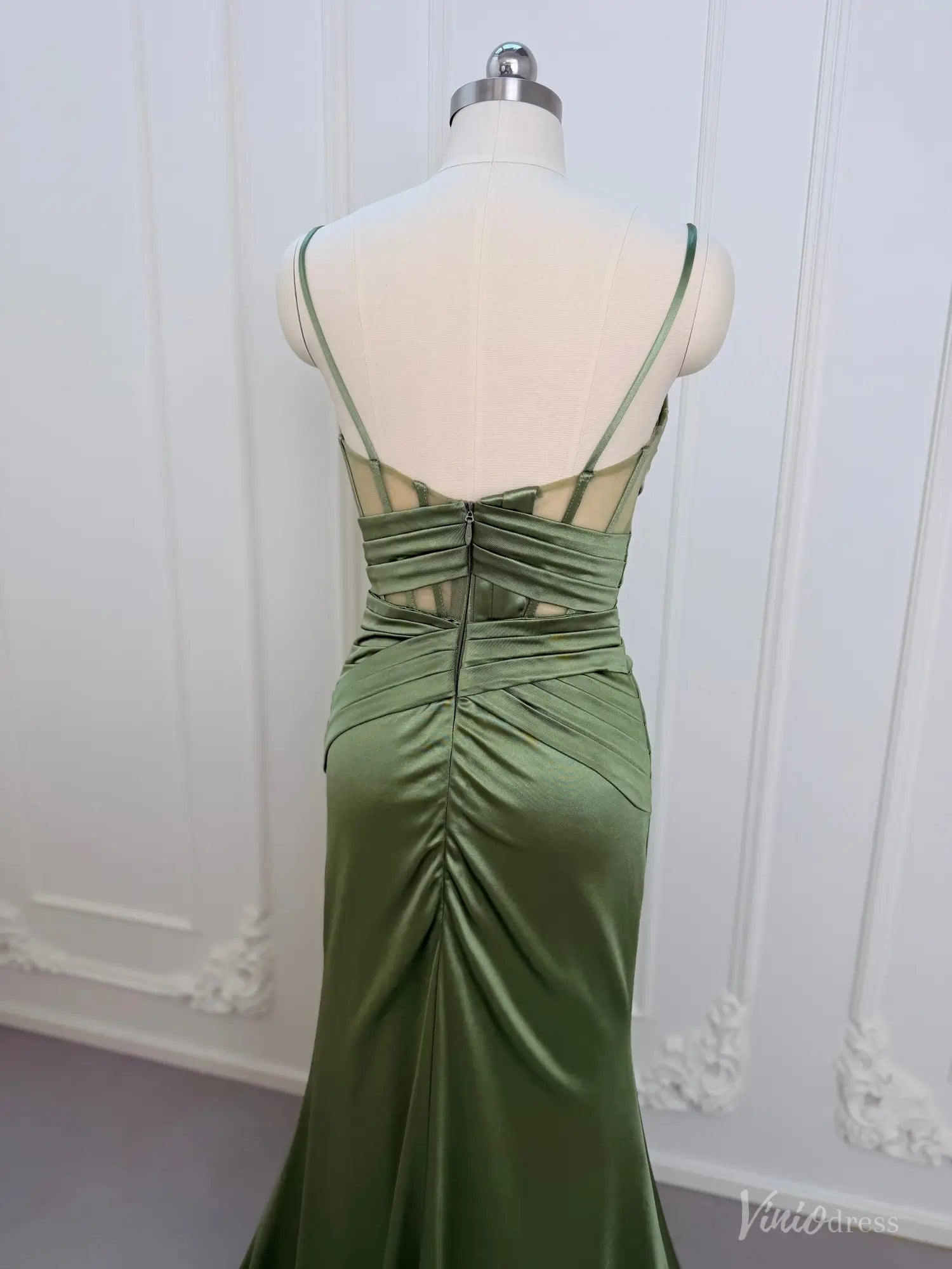 Sage green satin mermaid prom dress with a corset-style open back, ruched waist, and delicate spaghetti straps.