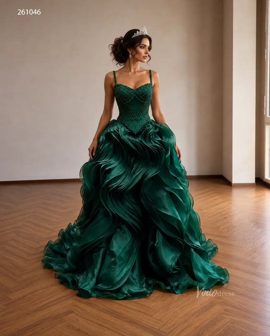 Emerald green quinceañera ball gown with a diamond-beaded corset, basque waist, and voluminous sculptural wave ruffle skirt.