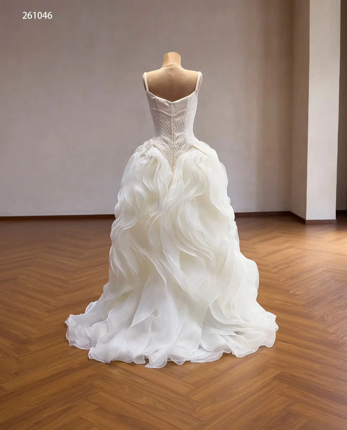 Ivory quinceañera ball gown with a diamond-beaded basque corset and a voluminous skirt of sculptural wave ruffles.