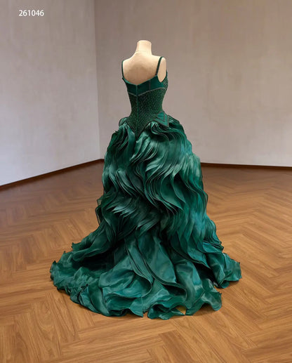 Emerald green quinceañera ball gown with a diamond-beaded basque corset and sculptural wave ruffle skirt.