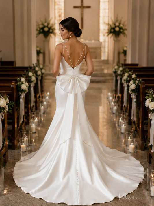 MN176 white satin mermaid wedding dress with spaghetti straps, a large back bow, and a button-down train in a church.