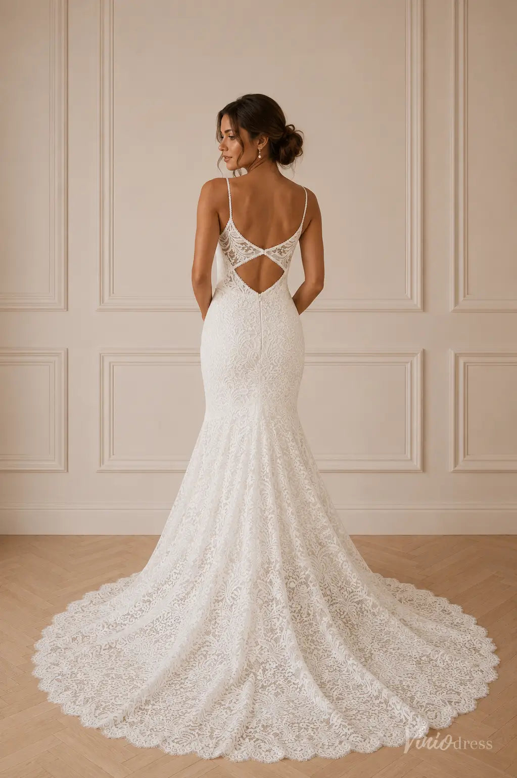 White lace mermaid wedding dress with spaghetti straps and an open back design featuring a small cutout detail.