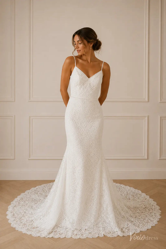 White lace mermaid wedding dress with spaghetti straps, a V-neckline, and a delicate scalloped train.