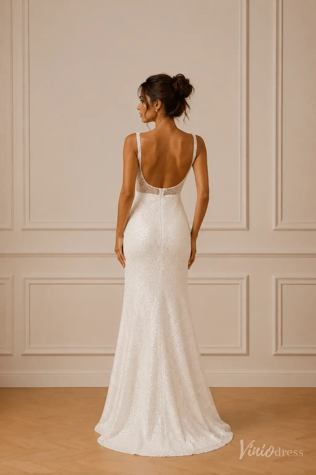White pearl-beaded sheath wedding dress with a low scoop back, wide straps, and a subtle sweep train.