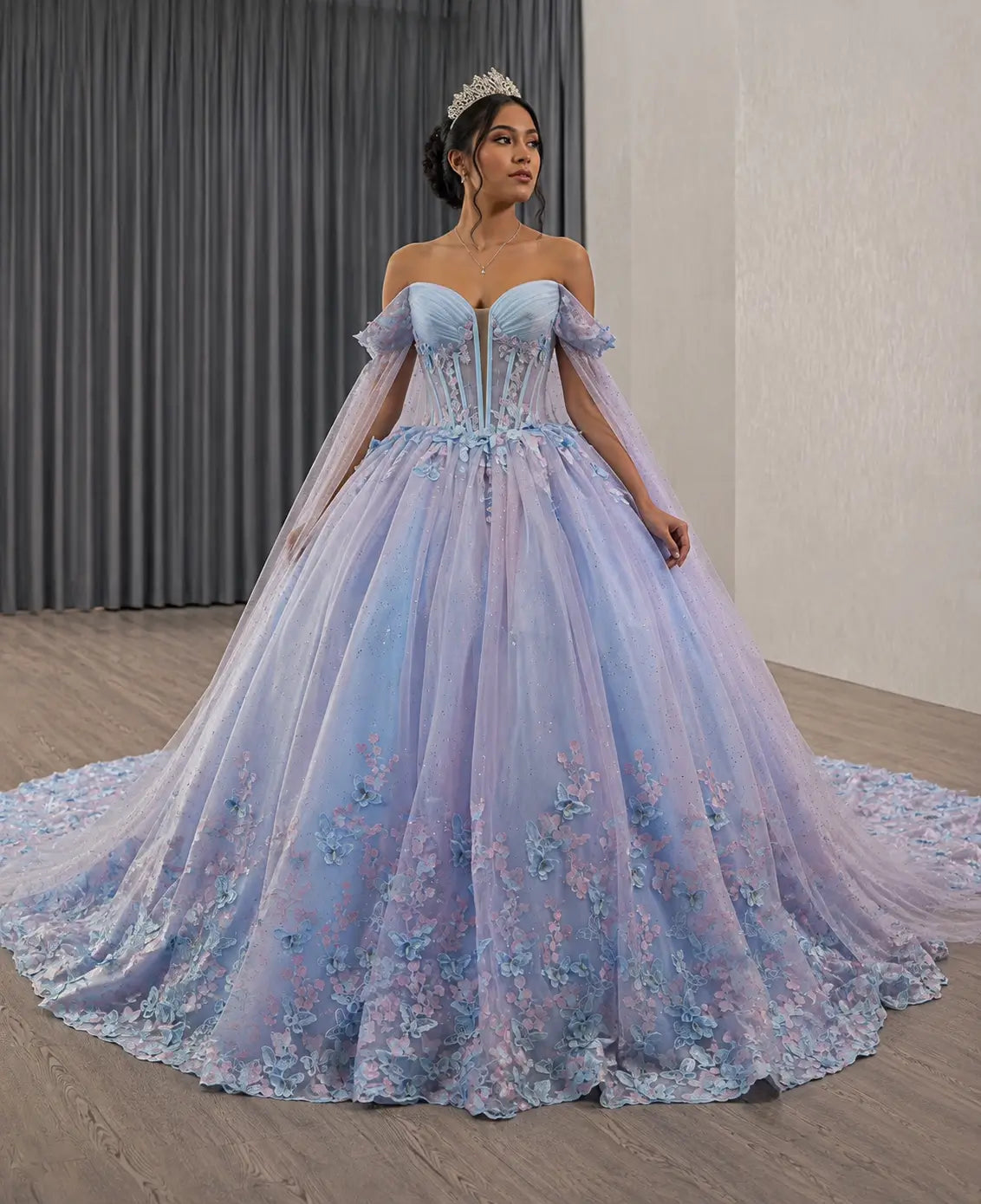 Off-shoulder blue and purple quinceañera ball gown with 3D butterfly appliqués, glitter tulle, and a sheer boned bodice.
