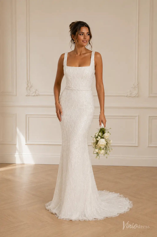 White sequined mermaid wedding dress with a square neckline and a long train, held by a bride with a white bouquet.