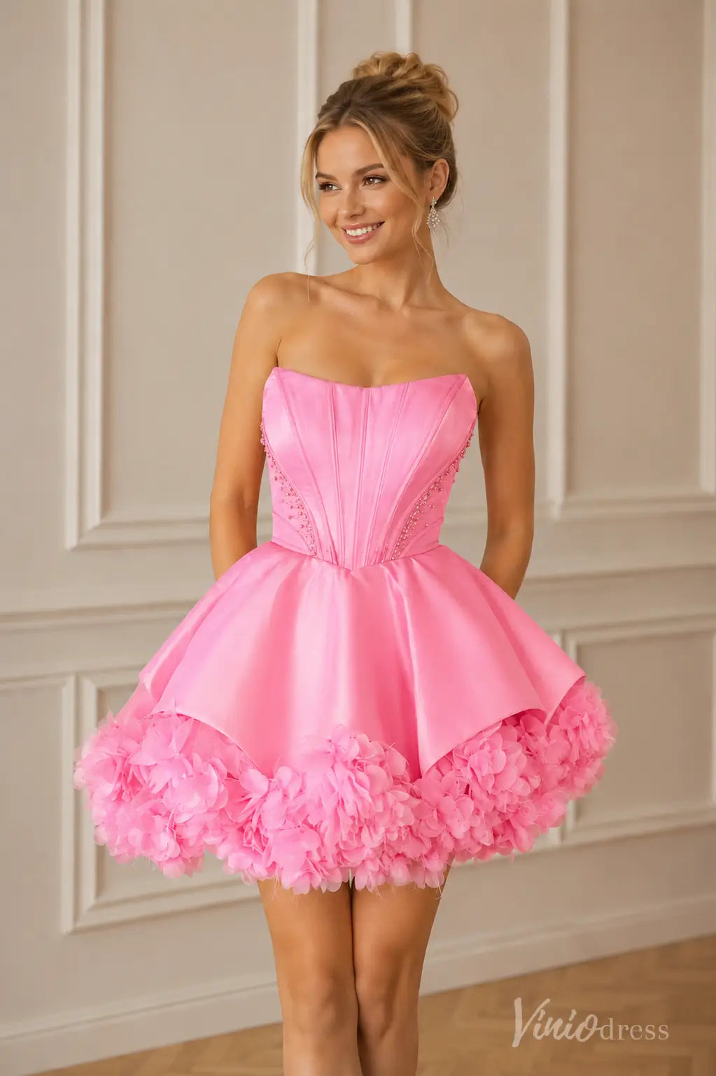 Pink strapless satin homecoming dress with a corset bodice and ruffled tulle hem.