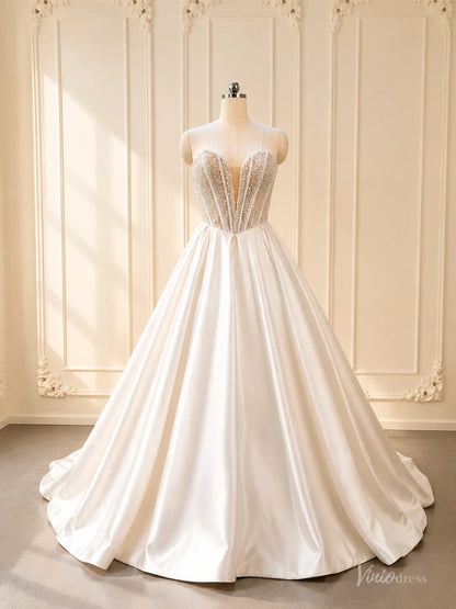 White strapless satin ball gown wedding dress with pearl beaded corset bodice and deep illusion plunge.