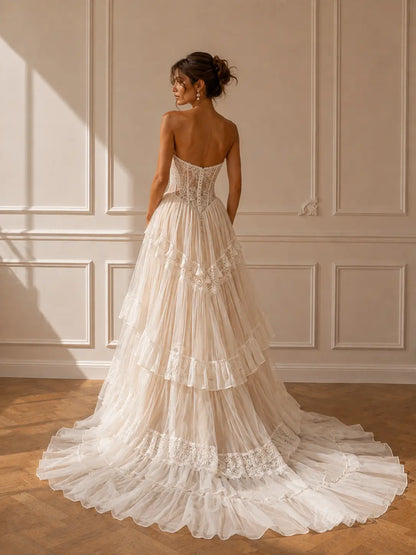 Strapless ivory wedding dress with a lace corset bodice and a tiered tulle skirt featuring intricate lace trim.
