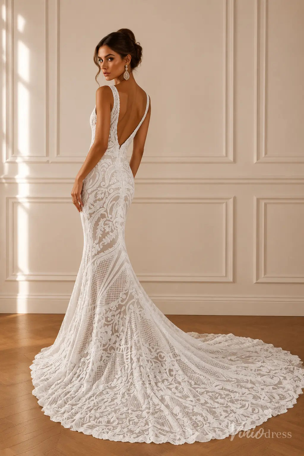 White mermaid wedding dress with ornate paisley lace, V-neckline, wide straps, and a dramatic plunging low back with train.