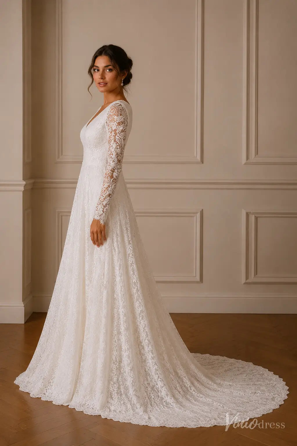 A-line wedding dress in white lace with sheer long sleeves, V-neckline, and a flowing scalloped train.