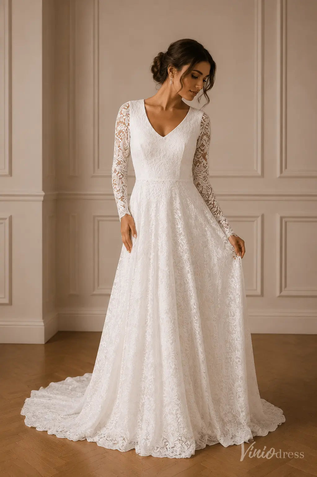 White A-line wedding dress with V-neckline, sheer long lace sleeves, and a flowing scalloped lace train.