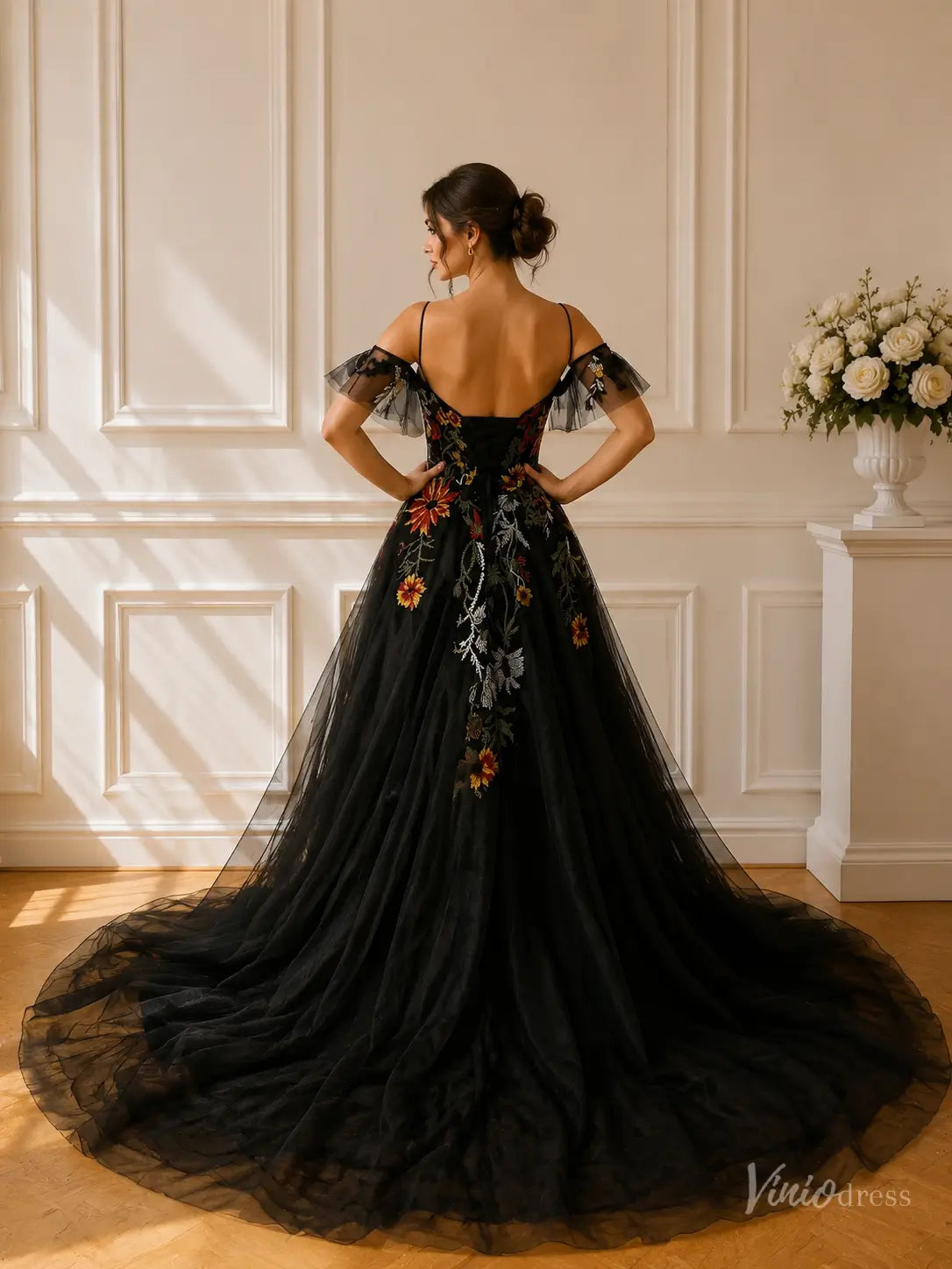 Black A-line wedding dress with meadow floral embroidery, cold shoulder sleeves, and a long tulle train.