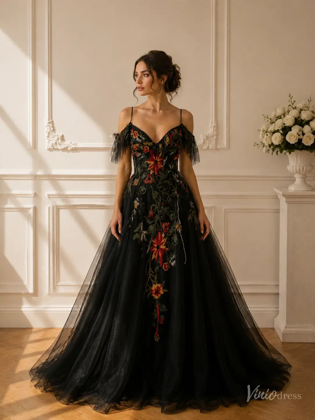 Black A-line wedding gown with vibrant floral embroidery, cold shoulder sleeves, spaghetti straps, and tulle skirt.