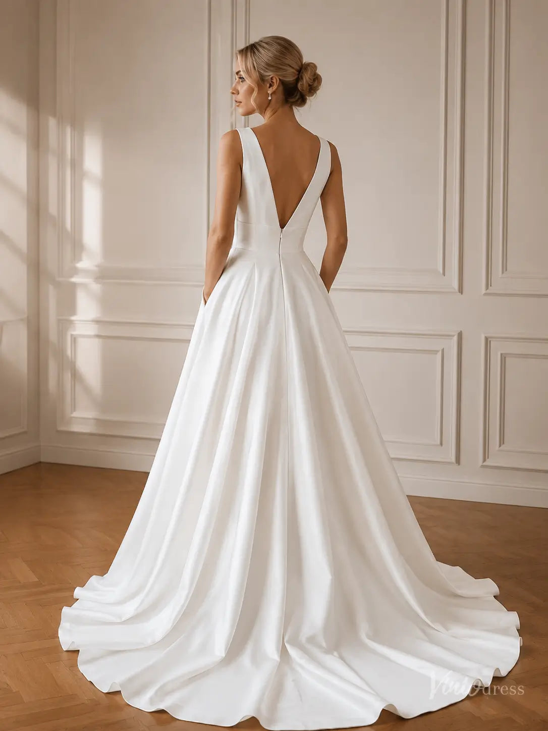 Minimalist white satin A-line wedding dress with a deep V-back, structured bodice, and hidden side pockets.